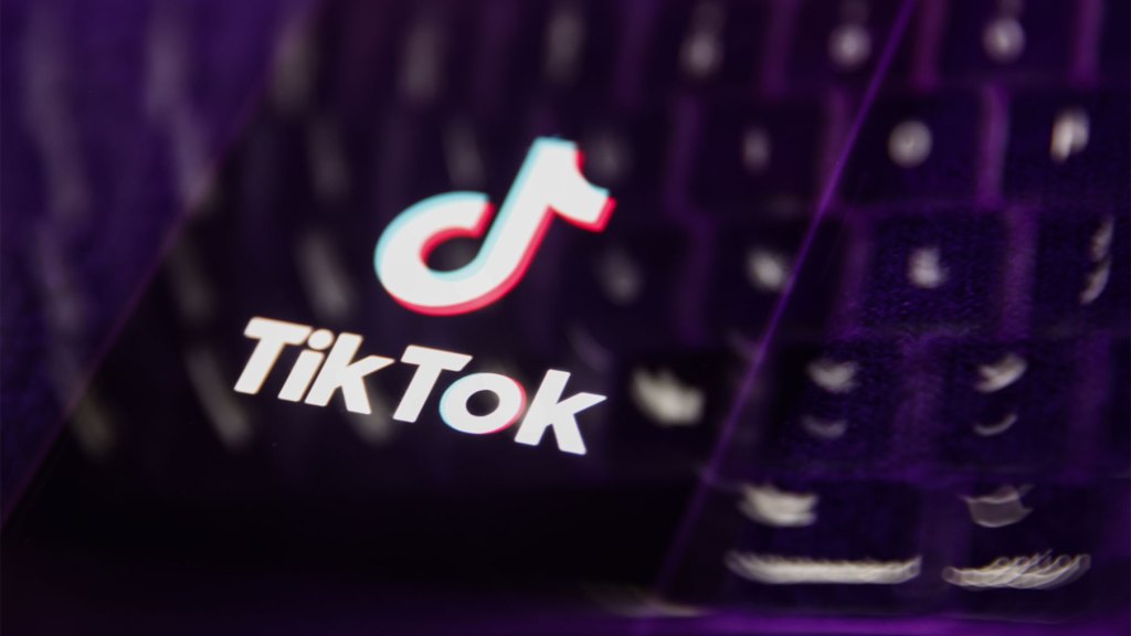 A laptop keyboard and TikTok logo displayed on a phone screen are seen in this multiple exposure illustration photo taken in Poland on March 17, 2024. (Photo by Jakub Porzycki/NurPhoto via Getty Images)